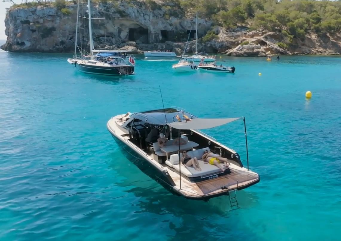 Forza 37 anchored in a turquoise bay with sunshade rigged