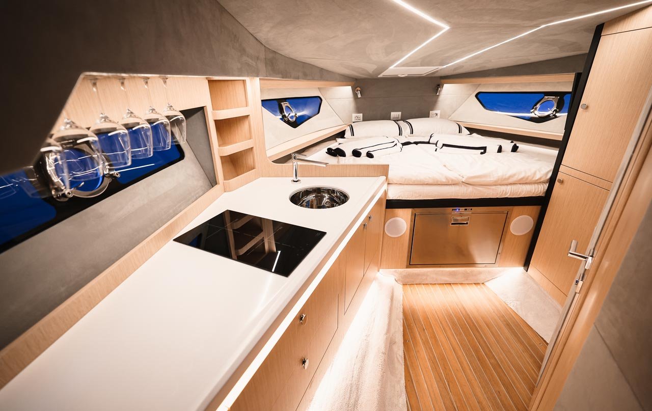 Cabin at dusk — galley, double berth and glowing hull windows